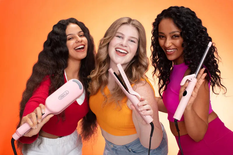 Three women with different hair textures holding TYMO curling irons and styling tools