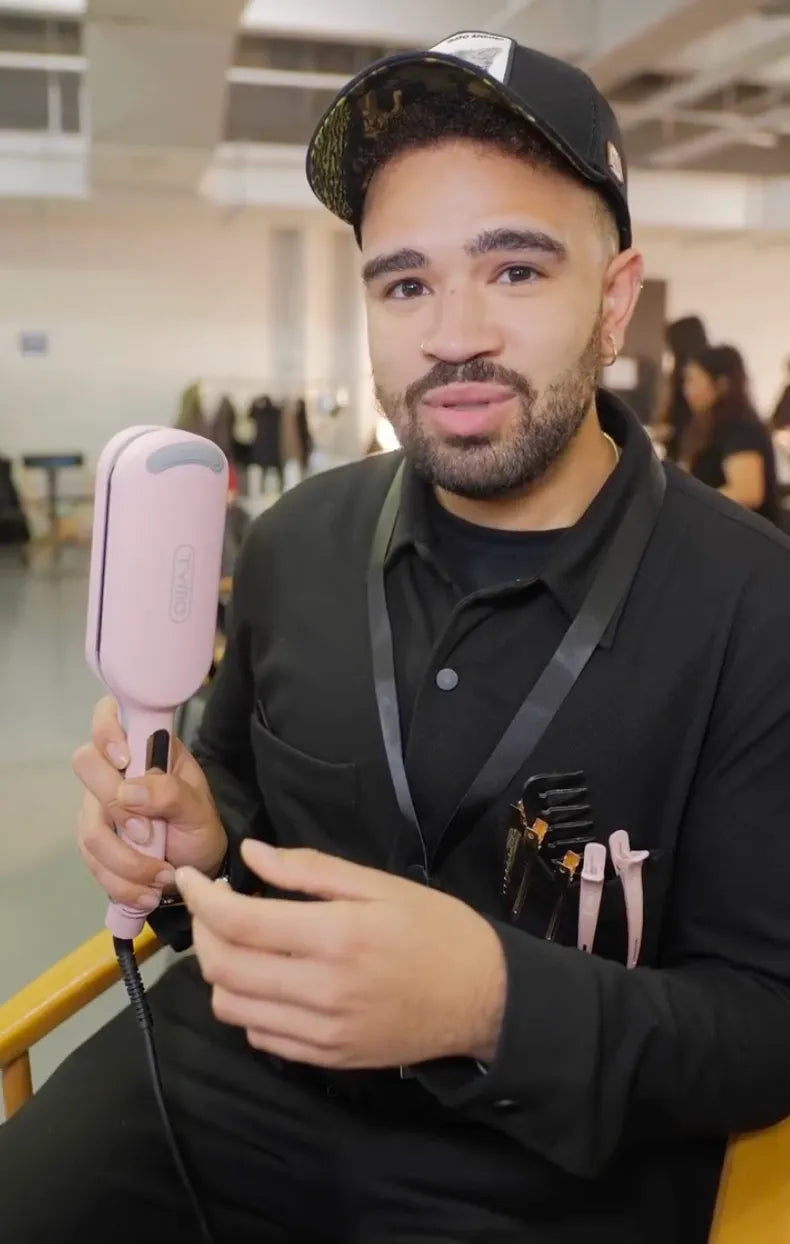 Stylist using ROVY curling iron on model hair