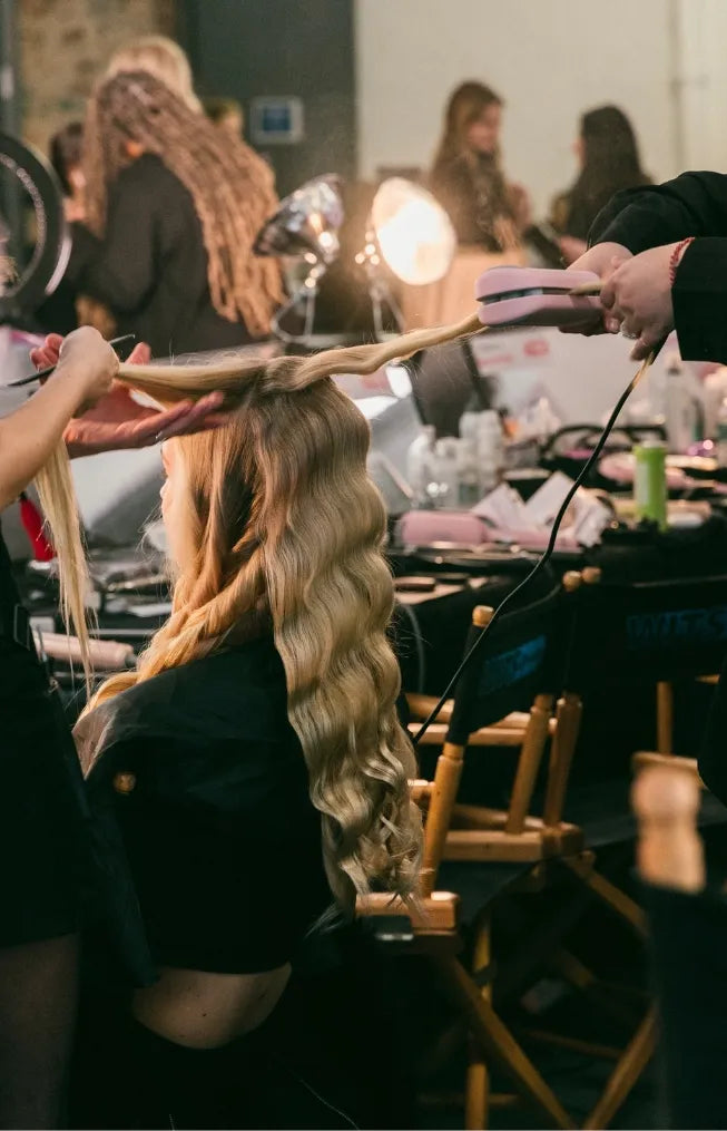 Stylist using ROVY curling iron on model hair